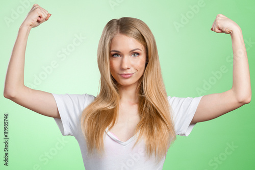 Pretty young blonde woman throwing her arms up into the air in jubilation of her success
