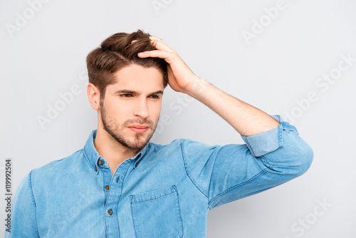 Portrait of handsome stylish young man touching his hair