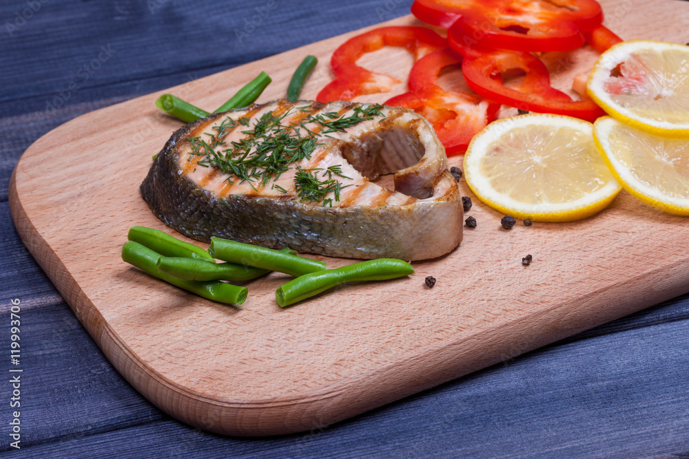 grilled steak salmon, lemon and salad on the board grilled steak salmon, lemon and salad on the board