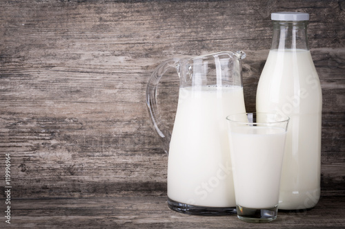 Milch in Krug, Flasche und Glas auf Holz Hintergrund. photo