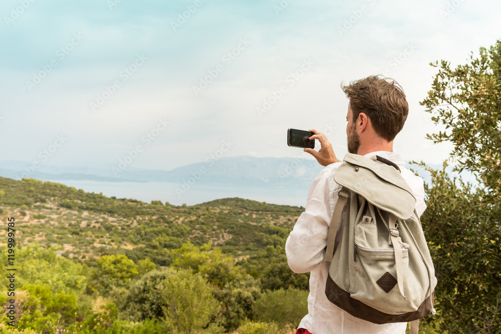 Tourist man takes a photo of beautiful landscape Tourist man takes a photo of beautiful landscape