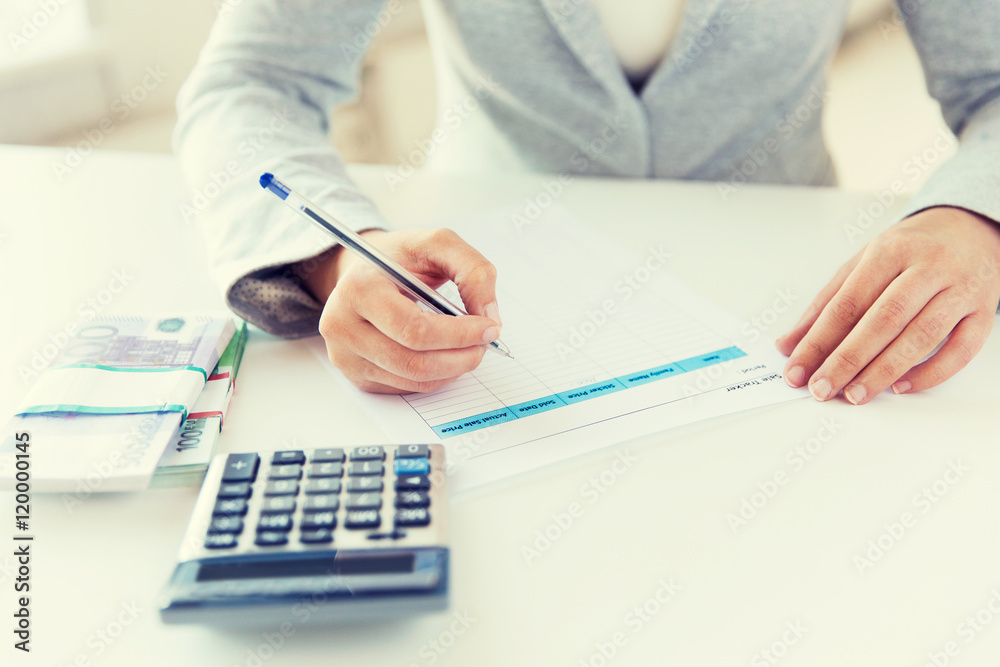 close up of hands counting money with calculator close up of hands counting money with calculator