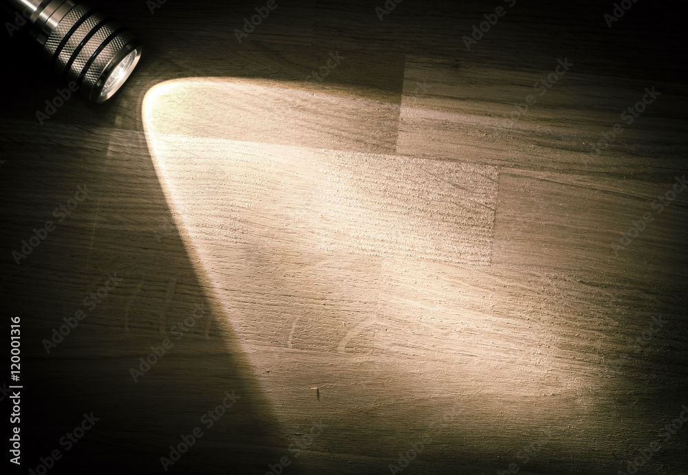Flashlight and a beam of light in darkness. A modern led light with bright  projection on dark wood table. Surface with copy space. Stock-Foto | Adobe  Stock
