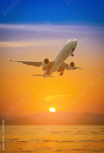 Plane flying above mountain at during sunset.