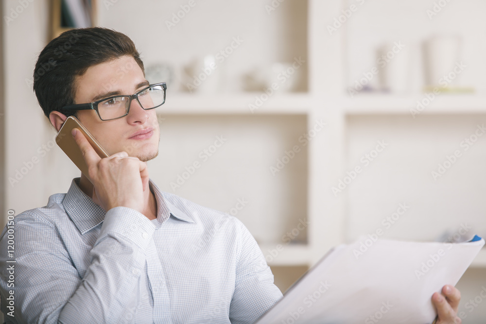 Man on phone holding paperwork Man on phone holding paperwork