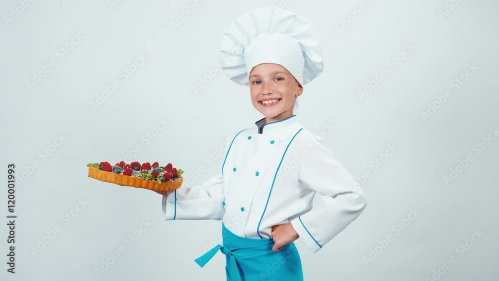 Portrait girl 7-8 years young chef cook holds cake handmade and smiling at camera Portrait girl 7-8 years young chef cook holds cake handmade and smiling at camera