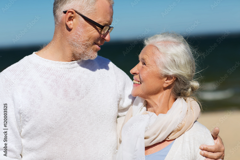 happy senior couple hugging on summer beach