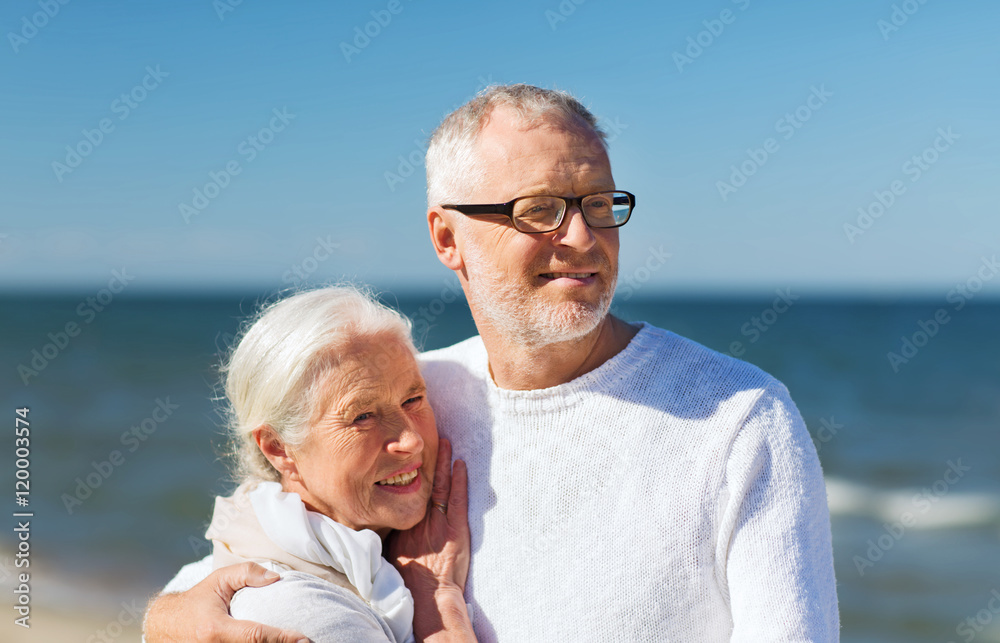 happy senior couple hugging on summer beach
