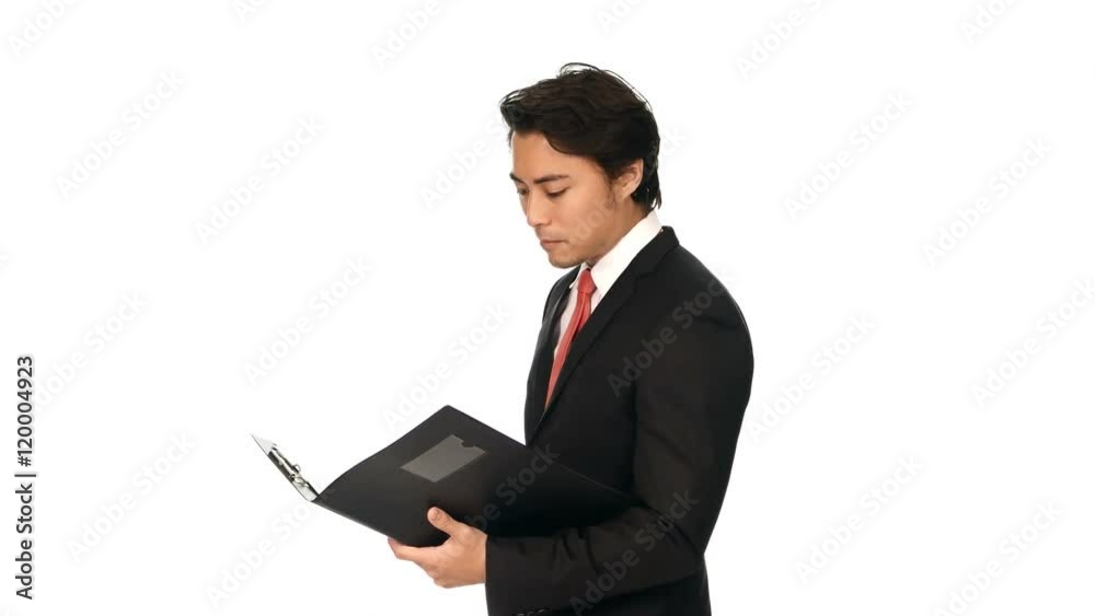 Attractive businessman in a black suit with a red tie, holding a clipboard standing against a white background smiling towards camera. Attractive businessman in a black suit with a red tie, holding a clipboard standing against a white background smiling towards camera.