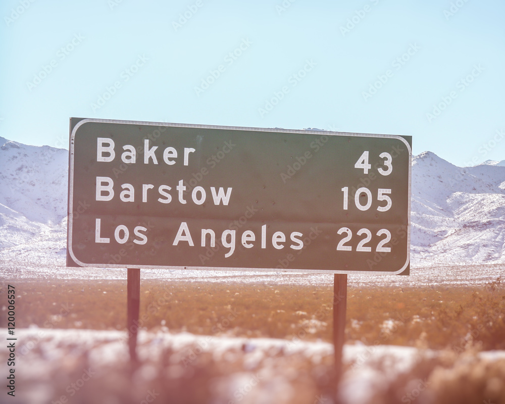 Naklejka premium Znak drogowy w Kalifornii Los Angeles Baker Barstow. Znak autostrady w Kalifornii pokazujący przebieg do miast Baker, Barstow i Los Angeles. Nakręcony na pustyni Mohave wzdłuż autostrady międzystanowej nr 15.
