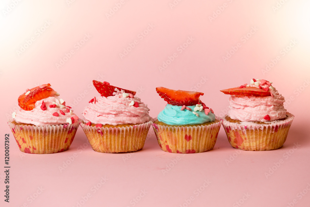 Closeup of colorful cupcakes with sprinkles and fresh strawberry