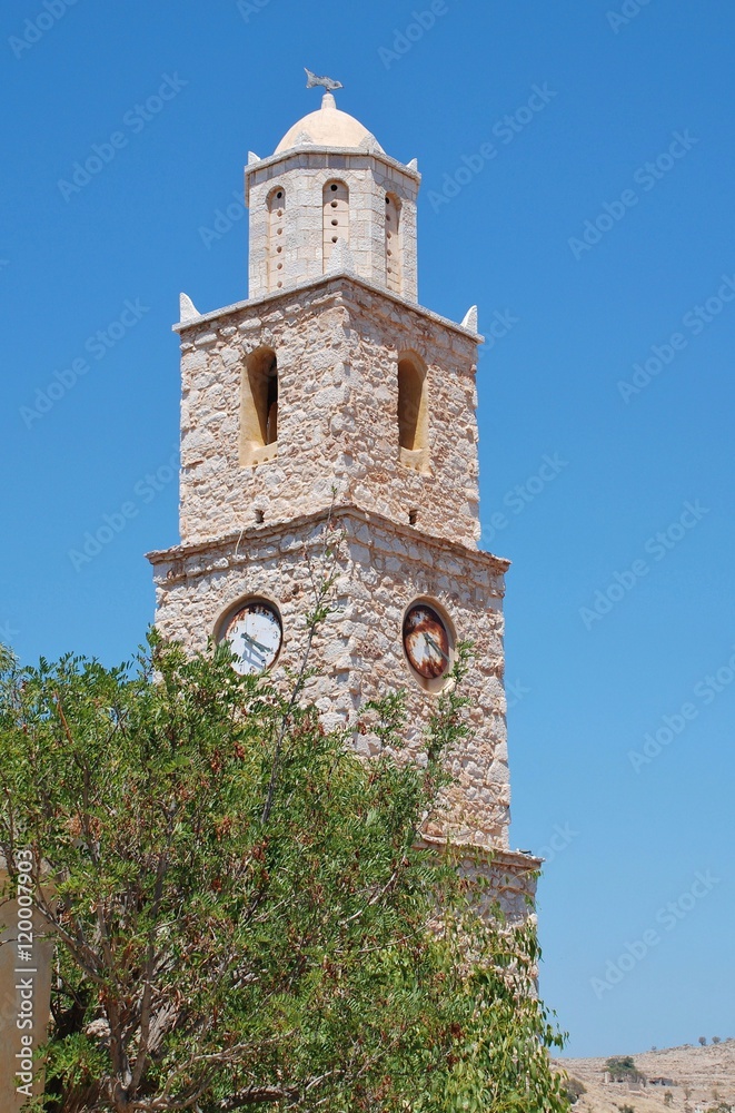 The old stone clock tower at Emborio on the Greek island of Halki. The clock has been stopped at four twenty for many years.