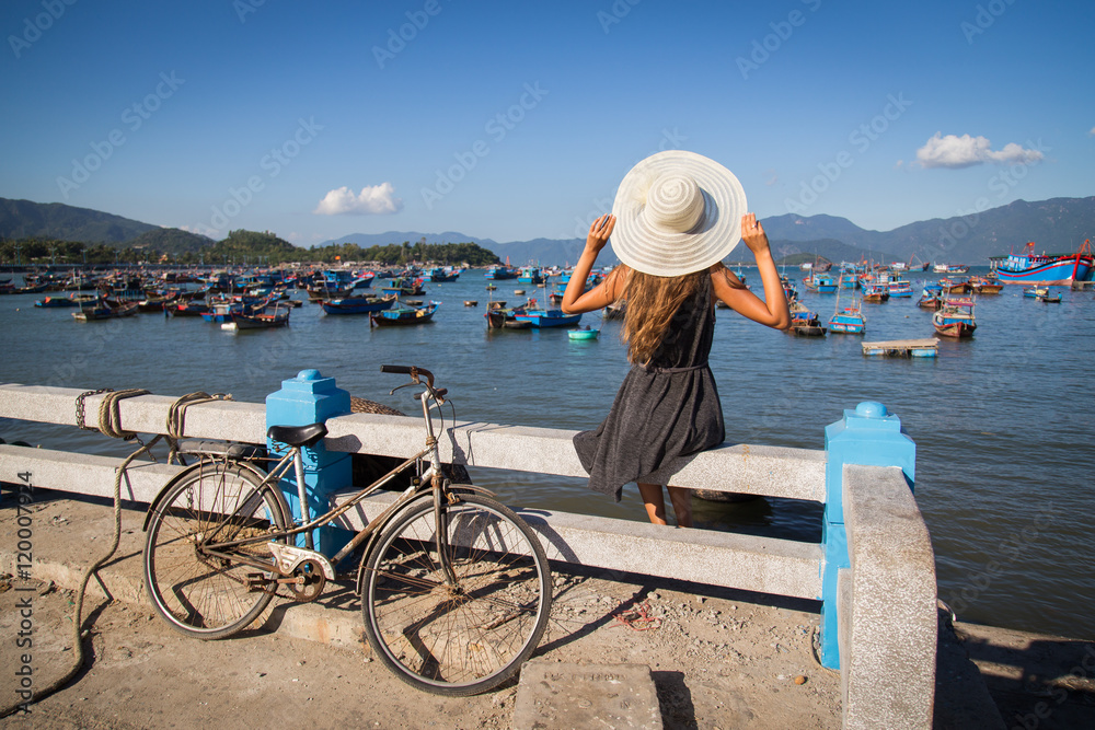 Woman near the water in the harbor boat tour Vietnam in the white hat
