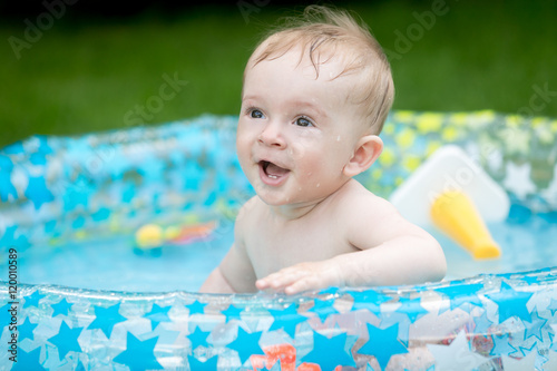 Portrait of 9 months old baby boy having fun in inflatable swimm