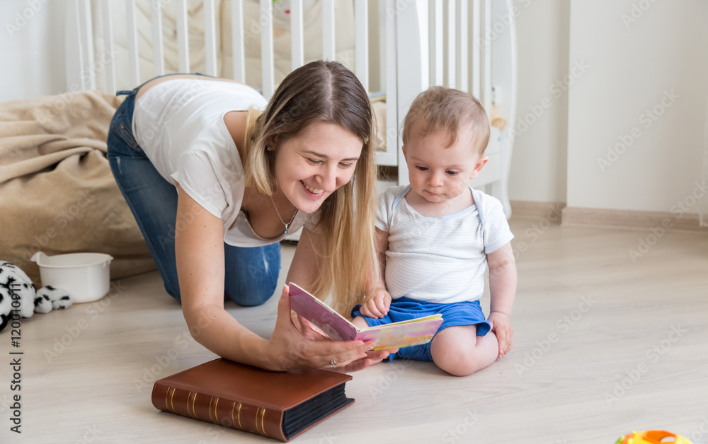 Happy mother reading book to her 10 months old baby boy on floor Happy mother reading book to her 10 months old baby boy on floor