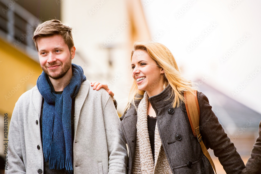 Young woman and man on a walk in town Young woman and man on a walk in town