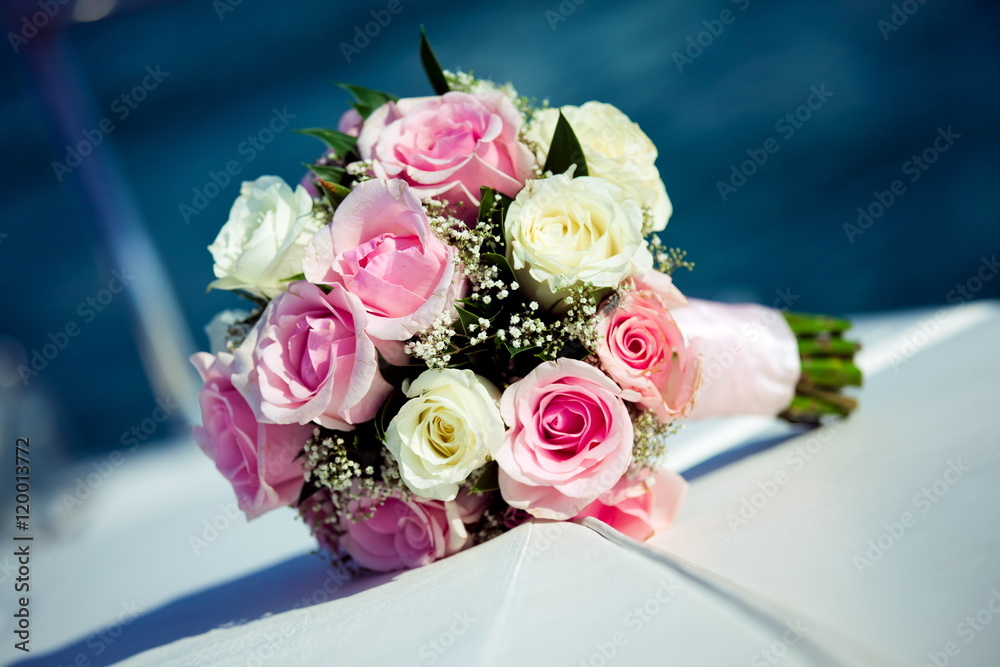 Φωτογραφία Bouquet of red and white roses flowers on the yacht with blue sea defocused back