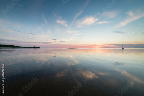 Beautiful summer sunset at the river with blue sky, red and oran