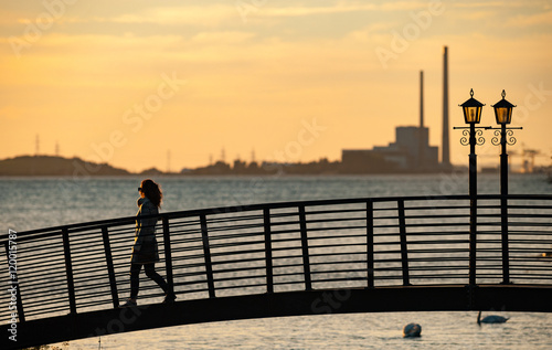 Silhouette of woman crossing footbridge in the town of Glin in County Limerick, Ireland