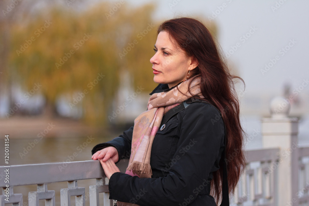 Portrait of a young girl in autumn park on background of  a yellow leaves trees.