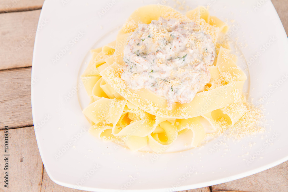 Pappardelle with chanterelle and cream on a wooden background
