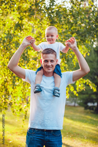 Father holding his son on shoulders in park
