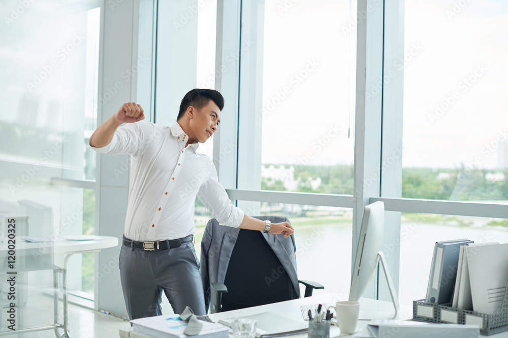Vietnamese businessman stretching back after hard work Stock Photo