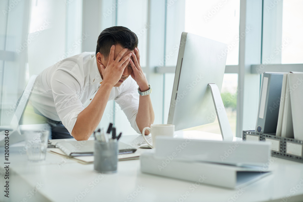 Anxious businessman covering face with his hands Anxious businessman covering face with his hands