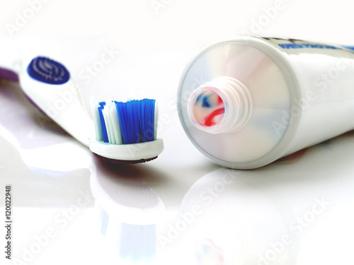 toothbrush and open toothpaste tube on the background, shallow depth of field