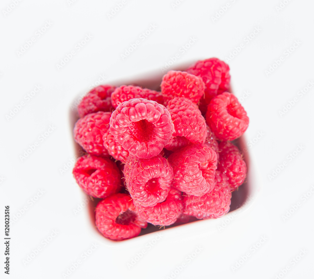 Fototapeta premium Raspberries: a bowl of fruit on white background