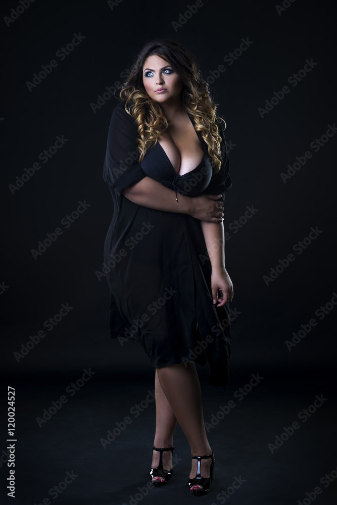 Young beautiful caucasian plus size model in underwear, xxl woman on black  background Stock Photo
