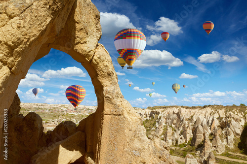 Hot air balloons flies in blue sky in Kapadokya, Turkey