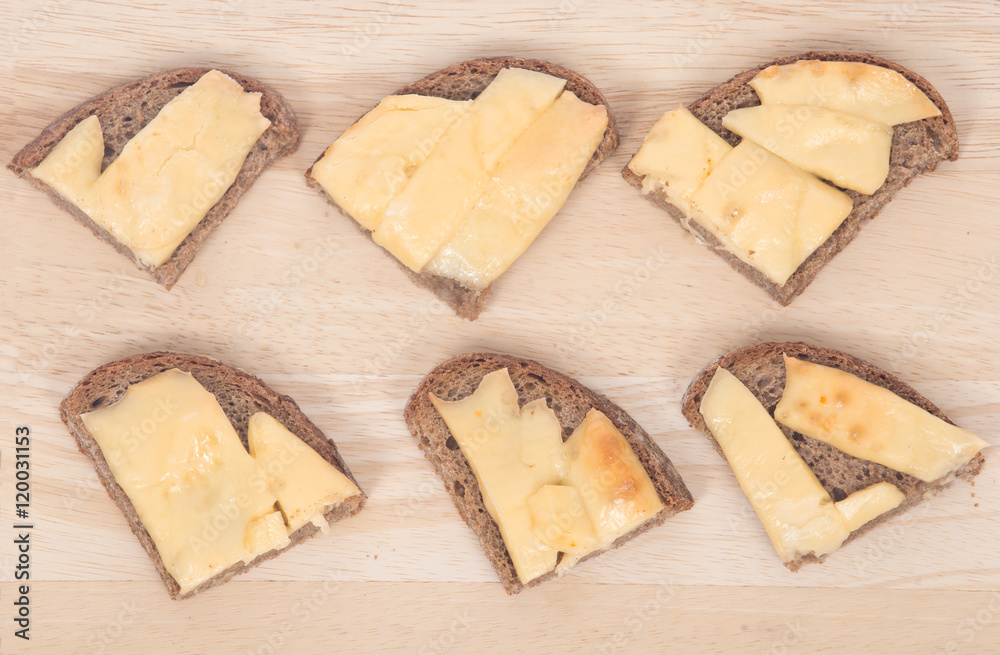 Hot sandwiches on cutting board with home made rye bread and melting cheese Hot sandwiches on cutting board with home made rye bread and melting cheese