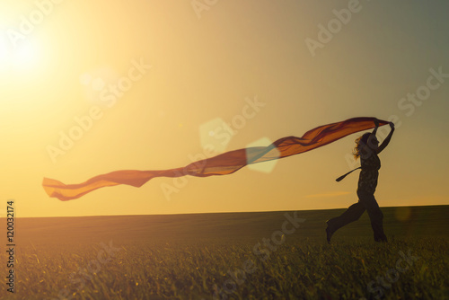 Young woman running on a rural road at sunset in summer field. Lifestyle freedom sports background. Happiness concept.