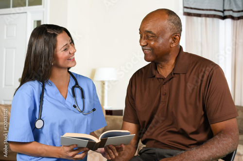 Health Care Worker and Elderly Patient Reading Book