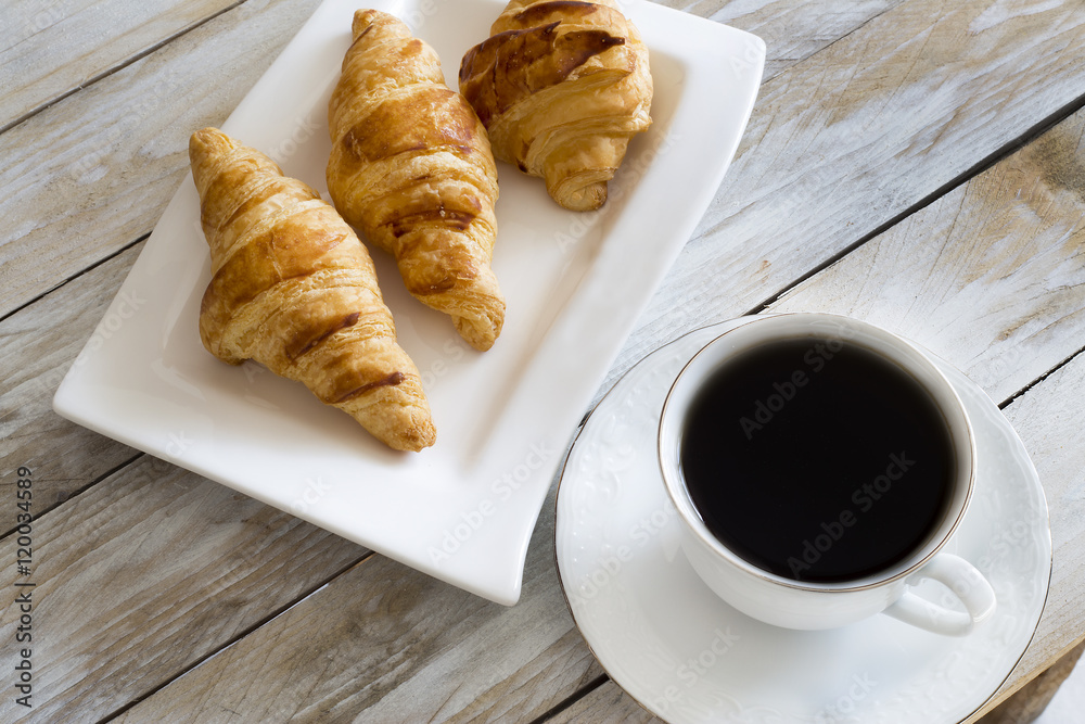 Croissants with coffee on the wooden table 
