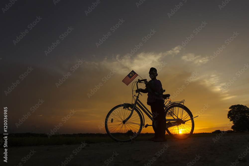 Fototapeta premium independence Day concept - Silhouette of young local boy on paddy field