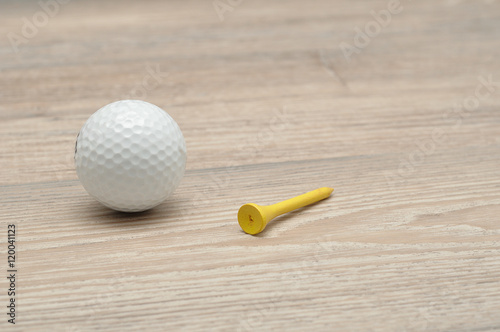 A golf ball with tee's isolated on a wooden background