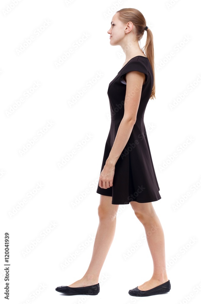 back view of walking woman. beautiful girl in motion. Isolated over white background. Blonde in a short black dress out of the frame.