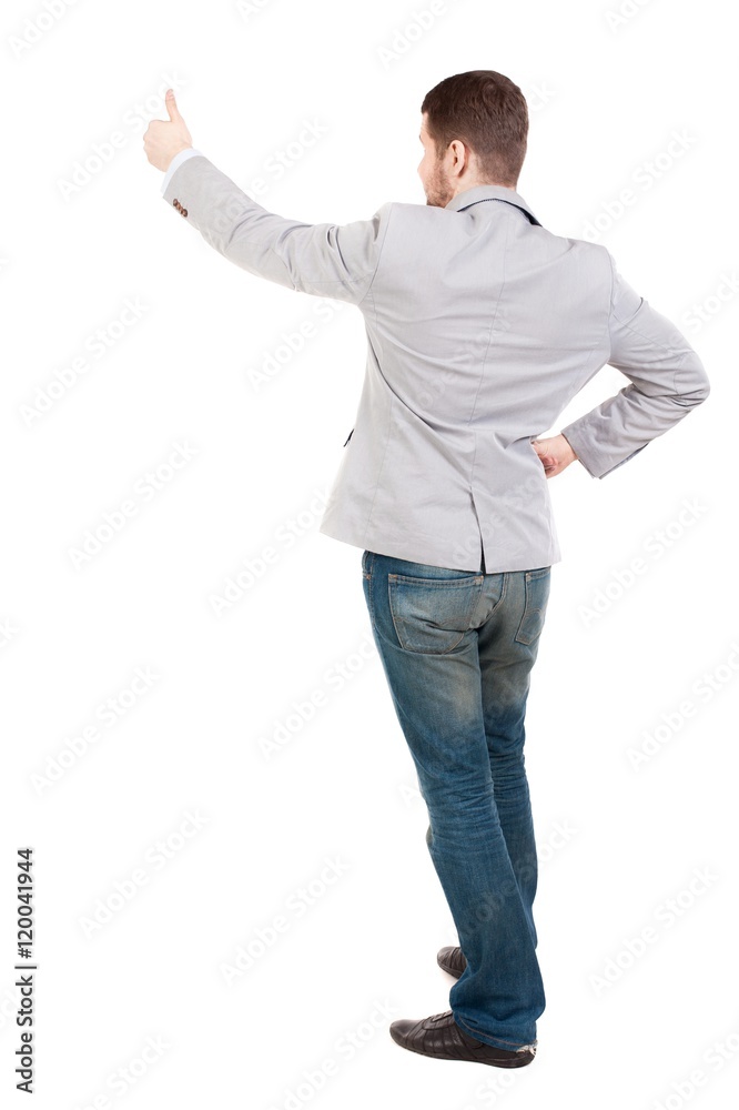 Back view of business man shows thumbs up. guy in a gray jacket waving his arms. Back view of business man shows thumbs up. guy in a gray jacket waving his arms.