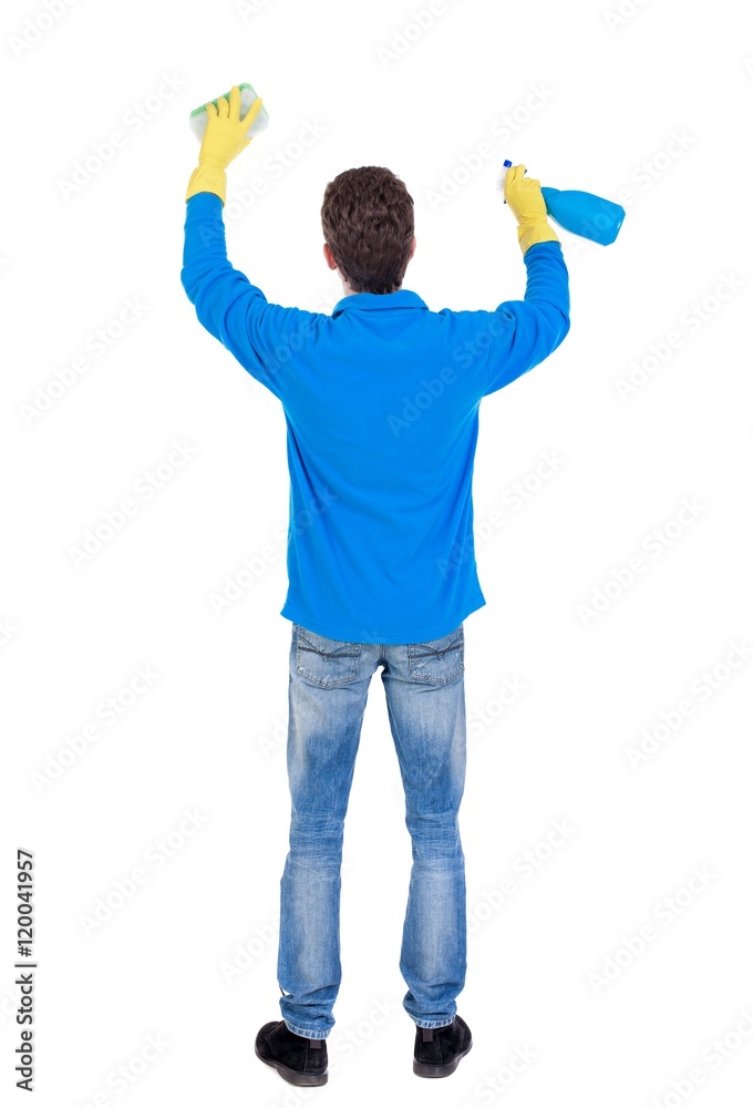 Back view of a cleaner man in gloves with sponge and detergent. girl watching. Curly guy in the blue sweater washes something over his head. Back view of a cleaner man in gloves with sponge and detergent. girl watching. Curly guy in the blue sweater washes something over his head.