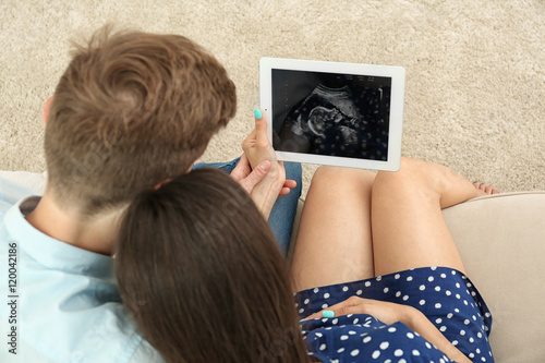 Young pregnant couple looki...
