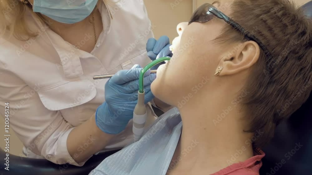 Woman at the dentist clinic office gets dental medical examination and treatment. Odontic and mouth health is important part of modern human life that dentistry help with. Woman at the dentist clinic office gets dental medical examination and treatment. Odontic and mouth health is important part of modern human life that dentistry help with.