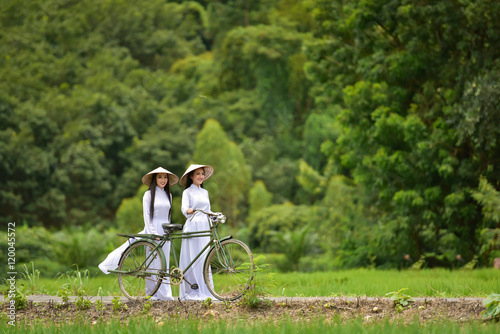 Women wear traditional Vietnamese .