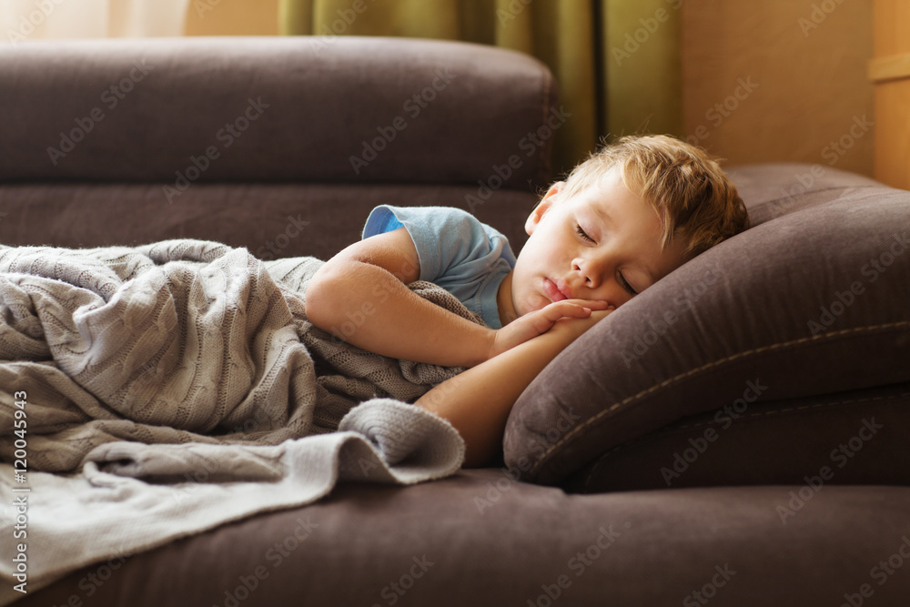 Illness child. Little boy sleeping wrapped in a blanket
