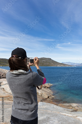 Wallpaper Mural hipster woman on rock  beach taking photo with camera for  blue Torontodigital.ca