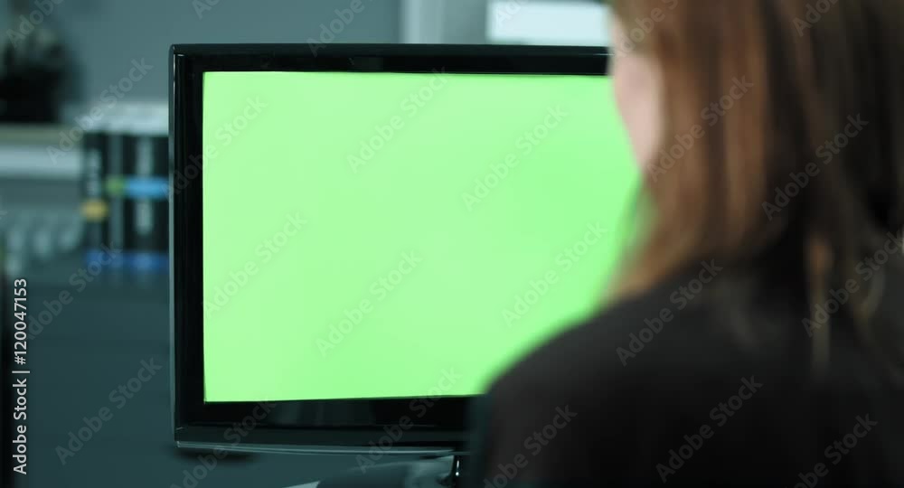 4K: Eine weibliche Angestellte arbeitet am Bildschirm. Der Fokus verläuft vom Bildschirm zu ihrem Gesicht. Der Bildschirm ist chromagrün. 4K: Eine weibliche Angestellte arbeitet am Bildschirm. Der Fokus verläuft vom Bildschirm zu ihrem Gesicht. Der Bildschirm ist chromagrün.