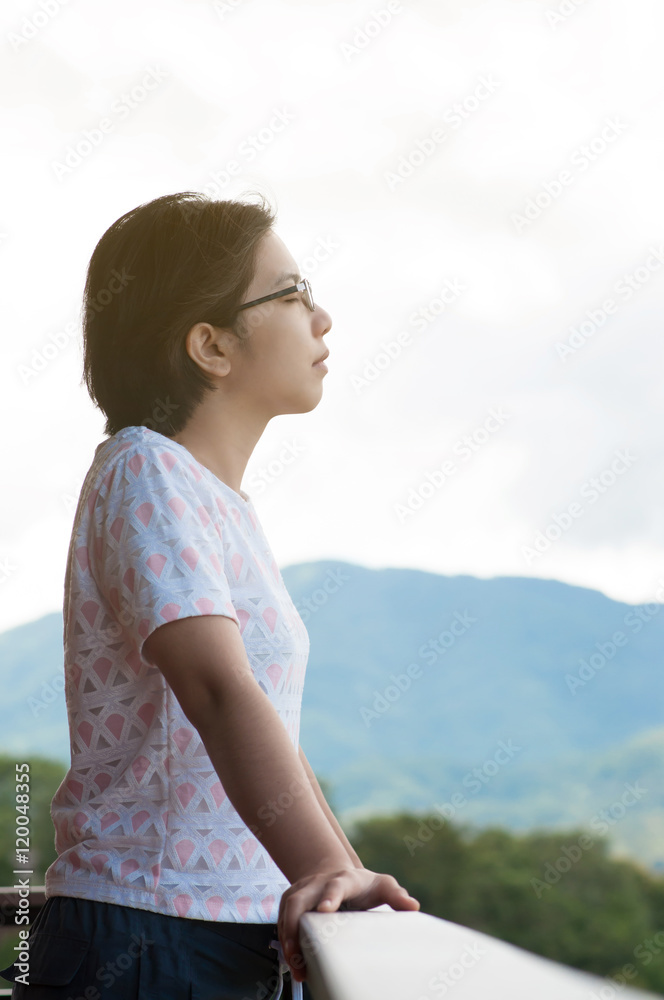 Asian woman standing at balcony and breathing fresh air. Asian woman standing at balcony and breathing fresh air.
