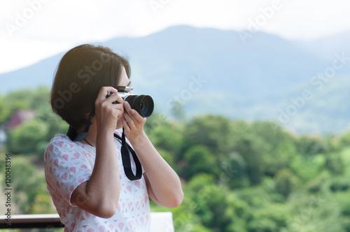Young Asian woman holding camera.