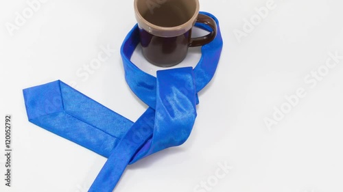 4K stop motion how to tie a blue necktie with double windsor knot and a tea cup photo